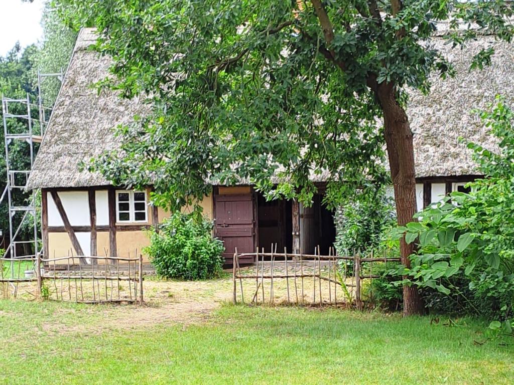 Fachwerkhaus mit Strohdach und Garten