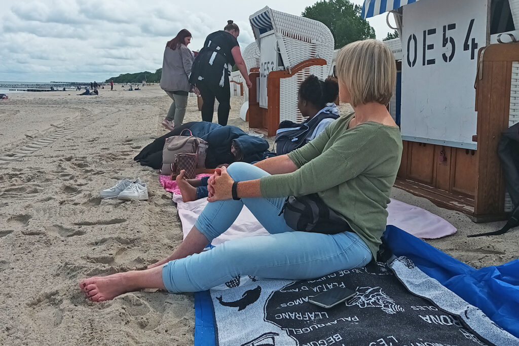 Menschen am Strand vor einem Strandkorb