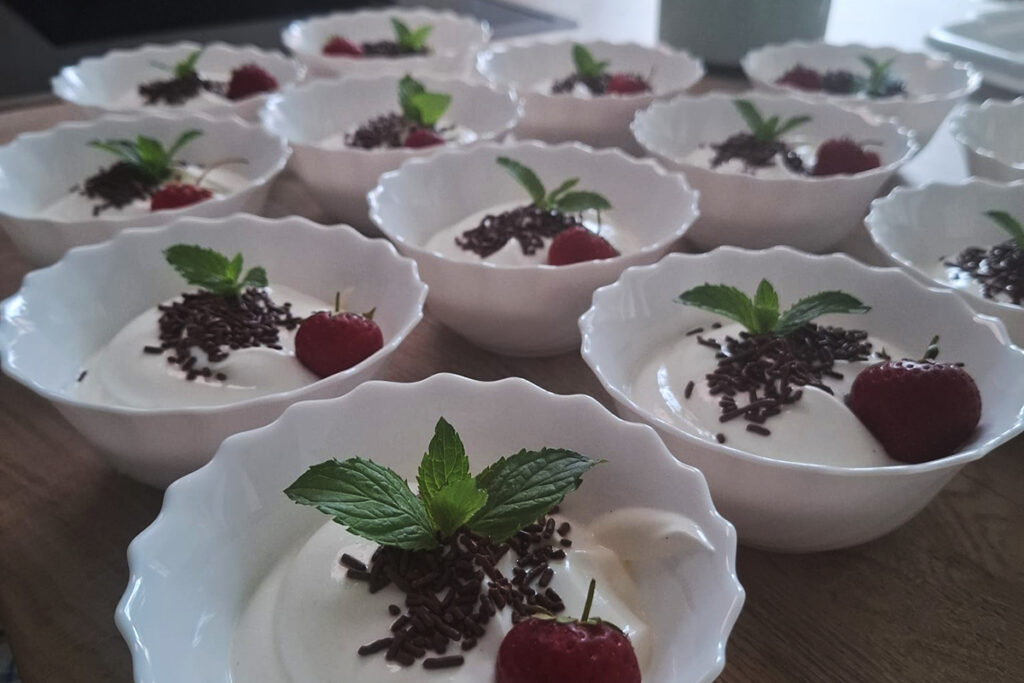 Schalen mit Dessert, dekoriert mit Erdbeeren und Minze.