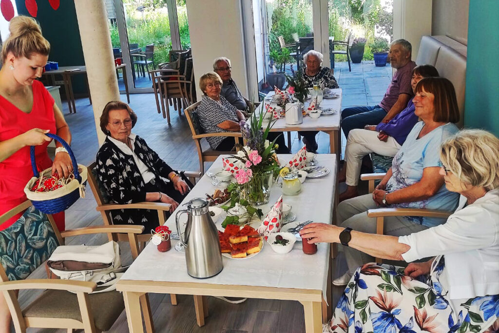 Personen an einem sch&ouml;n gedeckten Tisch in einem hellen Raum