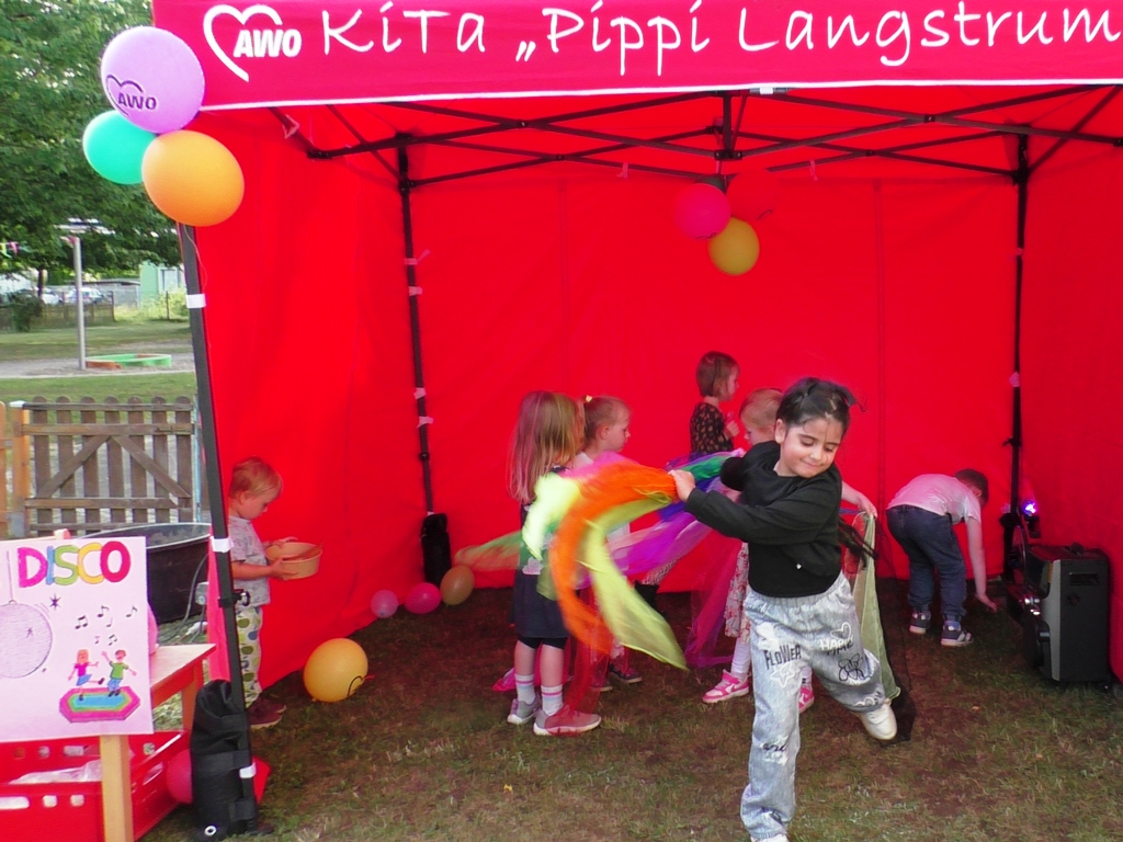 Kinder spielen in einem roten Zelt bei einem AWO-Event