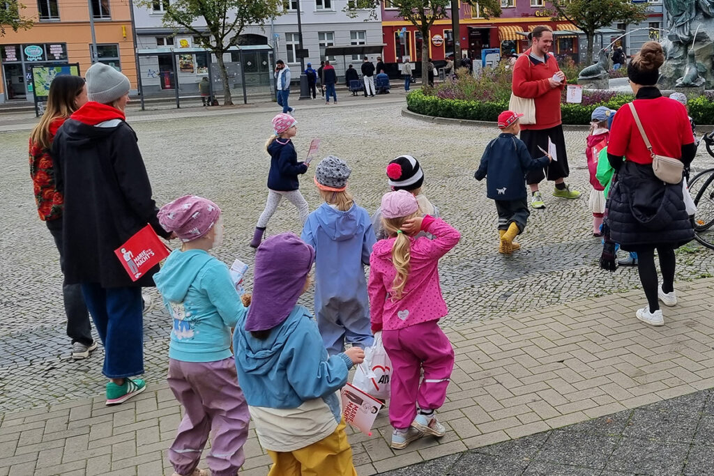 Eine Gruppe von Kindern und Erwachsenen auf einem Platz