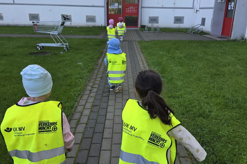 Kinder in gelben Warnwesten, die ein Geb&auml;ude betreten