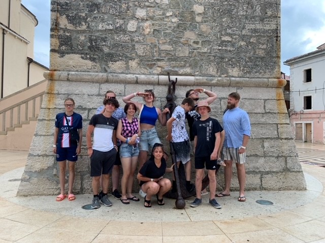 Gruppe von Menschen vor einem Steinbauwerk