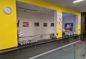 Essensausgabe in einer Kantine mit gelben Wänden