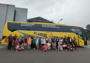 Eine Gruppe von Menschen vor einem gelben Reisebus