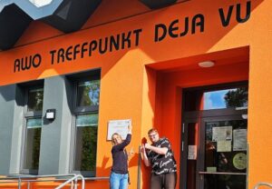Zwei Personen vor dem Eingang des AWO Treffpunkt Deja Vu Gebäudes