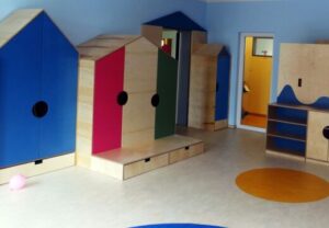 Innenraum einer Kindertagesstätte mit bunten Schränken und Spielzeug.