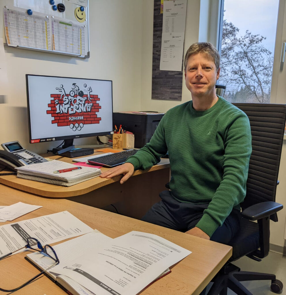 Eine Person sitzt an einem Schreibtisch in einem Büro.