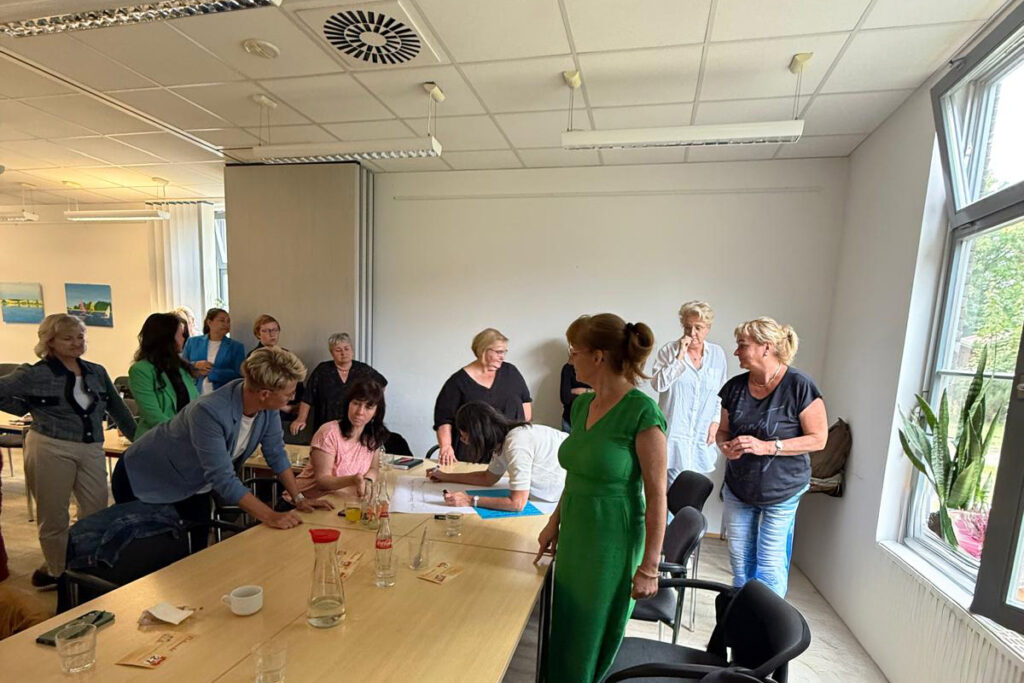 Eine Gruppe von Menschen versammelt sich in einem Konferenzraum.