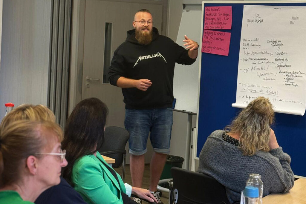 Eine Person h&auml;lt eine Pr&auml;sentation in einem Seminarraum.