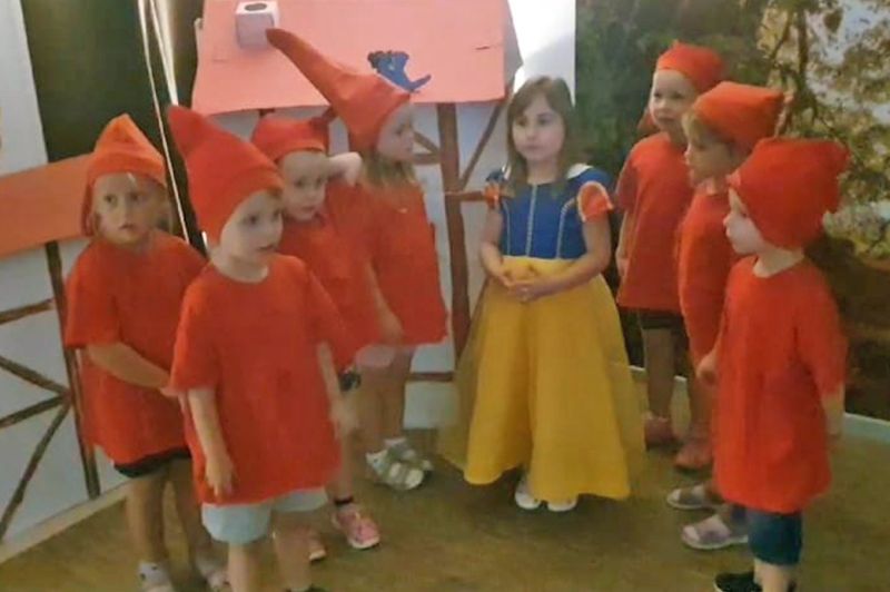 Kinder in Kostümen, die Schneewittchen und die sieben Zwerge darstellen.