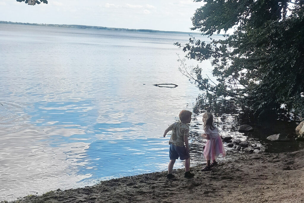 Zwei Kinder am Ufer eines Sees