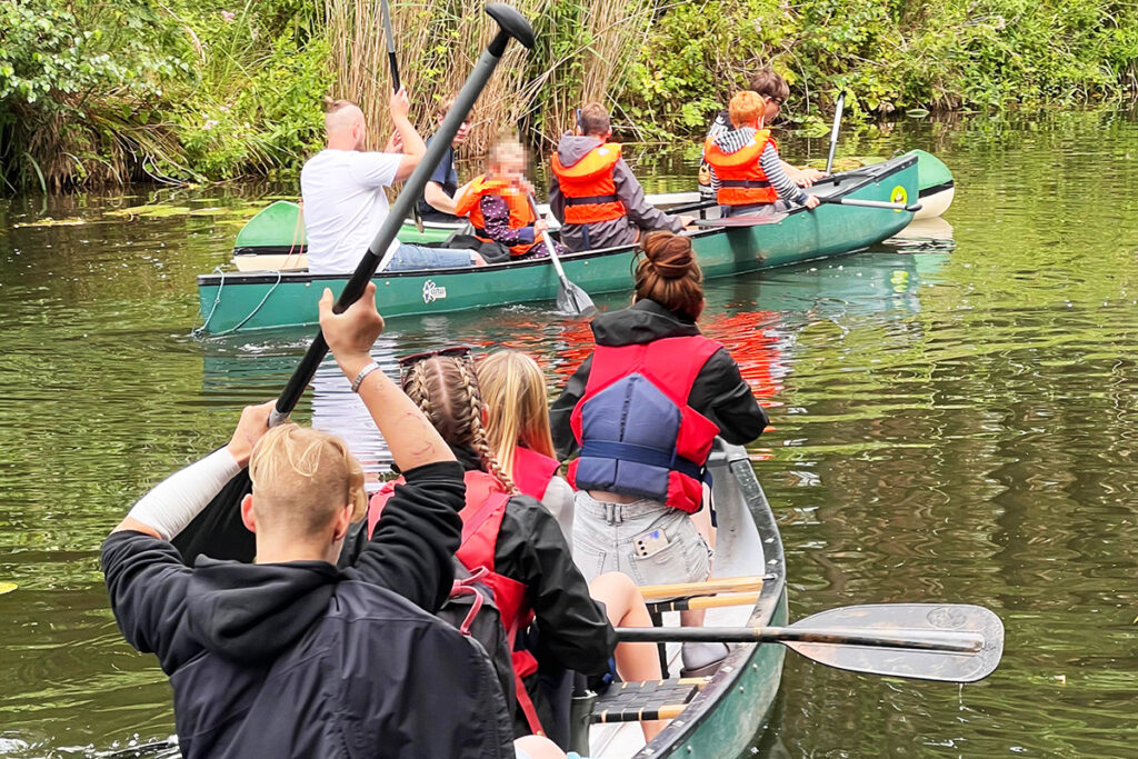 Zwei Gruppen von Menschen beim Kanufahren auf einem Fluss