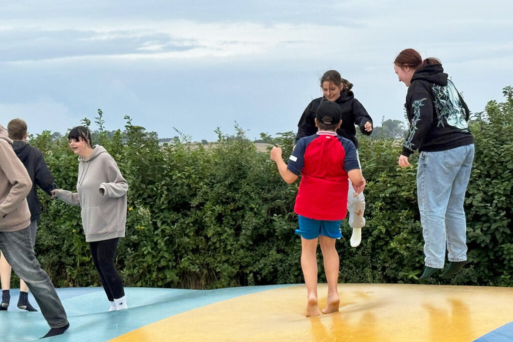 Gruppe von Personen, die auf einer H&uuml;pfburg springen.
