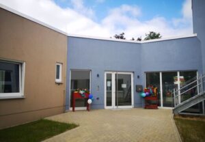 Zwei farbige Gebäude mit Luftballons an den Eingängen