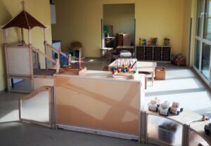 Bild eines hellen, freundlich eingerichteten Raums für Kinder mit Spielzeug und Klettermöglichkeiten.