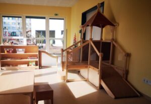 Innenansicht eines hellen Raumes mit Spielgeräten und Regalen