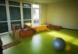 Innenraum einer Spielecke mit Holzspielzeug und Gymnastikball