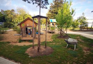 Spielplatz mit Holzhäuschen und Spielgeräten