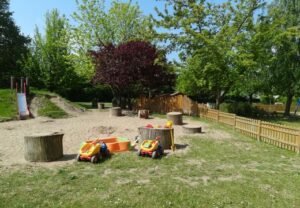 Spielplatz mit Sandkasten und Spielzeugautos