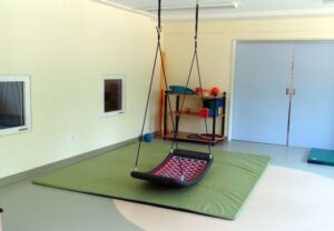 Innenansicht eines Raumes mit Schaukel und Matten