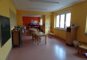 Innenansicht eines hellen Raums mit gelb gestrichenen Wänden, Möbel und Ausstattung für Kinder