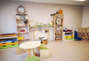 Ein Raum mit Musikinstrumenten und Möbeln für Kinder.