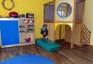Raum einer Kindertagesstätte mit Spielgeräten und Aufbewahrungsmöbeln