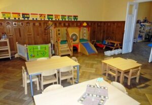 Innenraum einer Kindertagesstätte mit Spielgeräten und Tischen