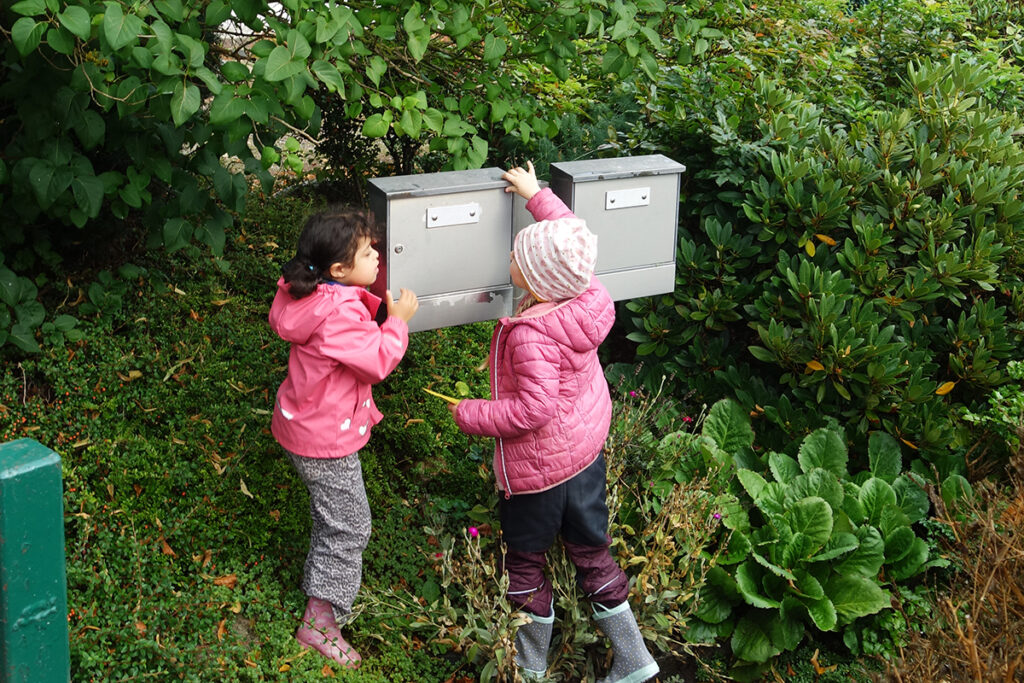 Zwei Kinder bei Briefk&auml;sten in einem Garten