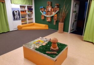 Innenansicht eines Raumes in einer sozialen Einrichtung mit Dekorationen und Spielen.