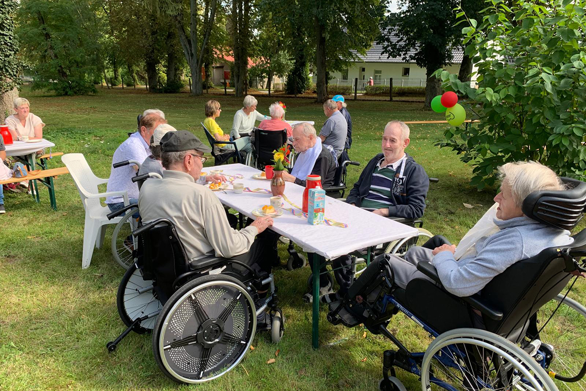 Menschen bei einem gemeinsamen Picknick im Freien.