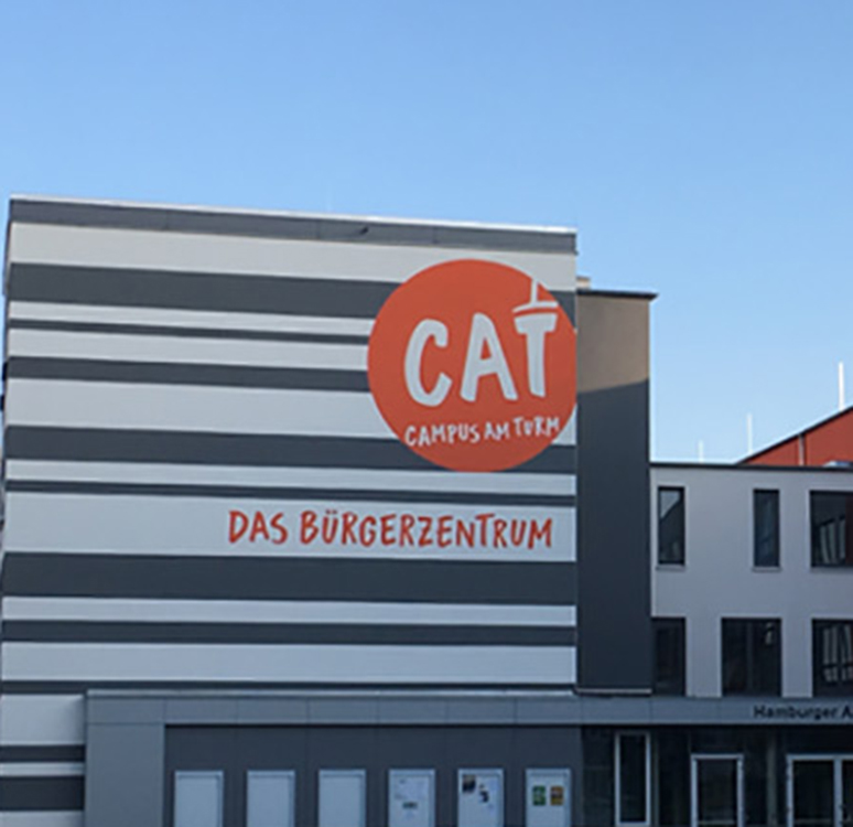 Außenansicht eines modernen Gebäudes mit dem Schriftzug 'CAT Campus am Turm'.