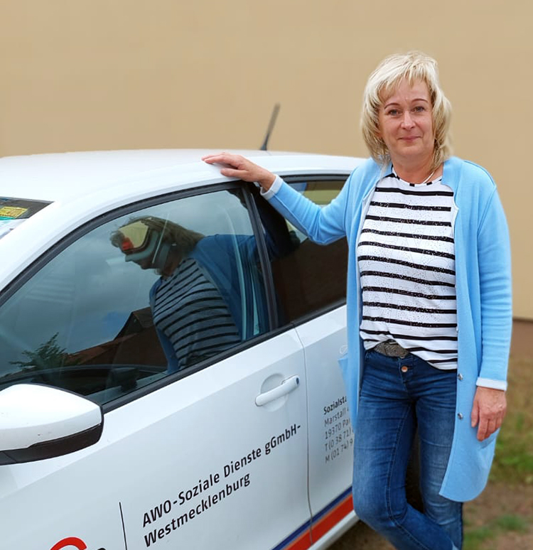 Frau lehnt am AWO-Fahrzeug