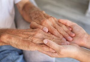 Eine junge Hand hält eine alte Hand