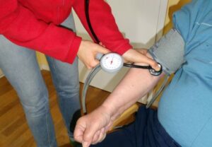 Person misst den Blutdruck einer anderen Person.