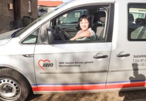 Eine Frau sitzt in einem Auto der AWO-Soziale Dienste gGmbH-Westmecklenburg.