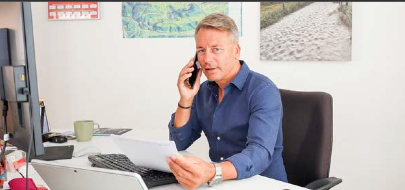 Mann am Schreibtisch telefoniert