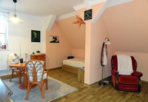 Wohnzimmer mit gemütlicher Sitzecke, Sessel, Tisch und Bettnische