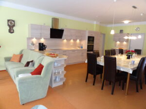 Ein wohnlicher Raum mit einer Küche und einem großen Esstisch.