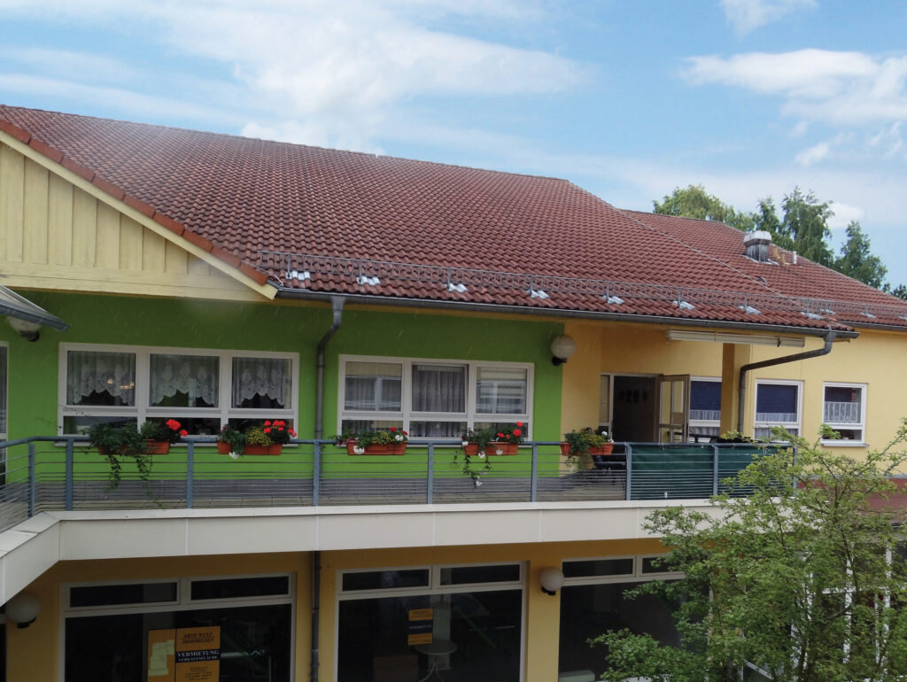 Bild eines zweistöckigen Gebäudes mit grün und gelb gestrichenen Wänden