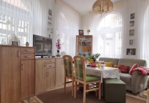 Wohnzimmer mit Tisch, Sofa und Schrankwand