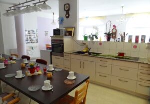 Innenraum einer Küche mit gedecktem Tisch und Küchenzeile.