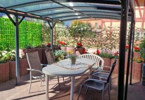 Überdachte Terrasse mit Tisch und Stühlen