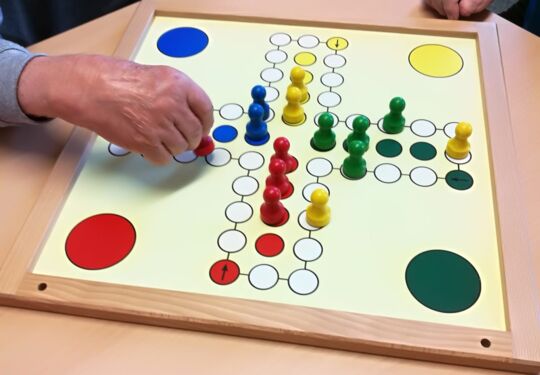 Zwei Hände spielen ein Brettspiel mit Spielfiguren