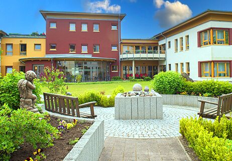 Hof mit Garten und Skulpturen, umgeben von Gebäude