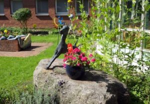 Ein Garten mit Skulptur und Blumenarrangement