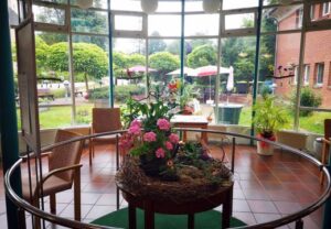 Innenansicht eines hellen Raumes mit Blick auf einen Garten