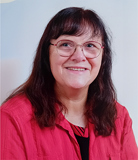 Porträt einer lächelnden Frau mit Brille und rotem Hemd